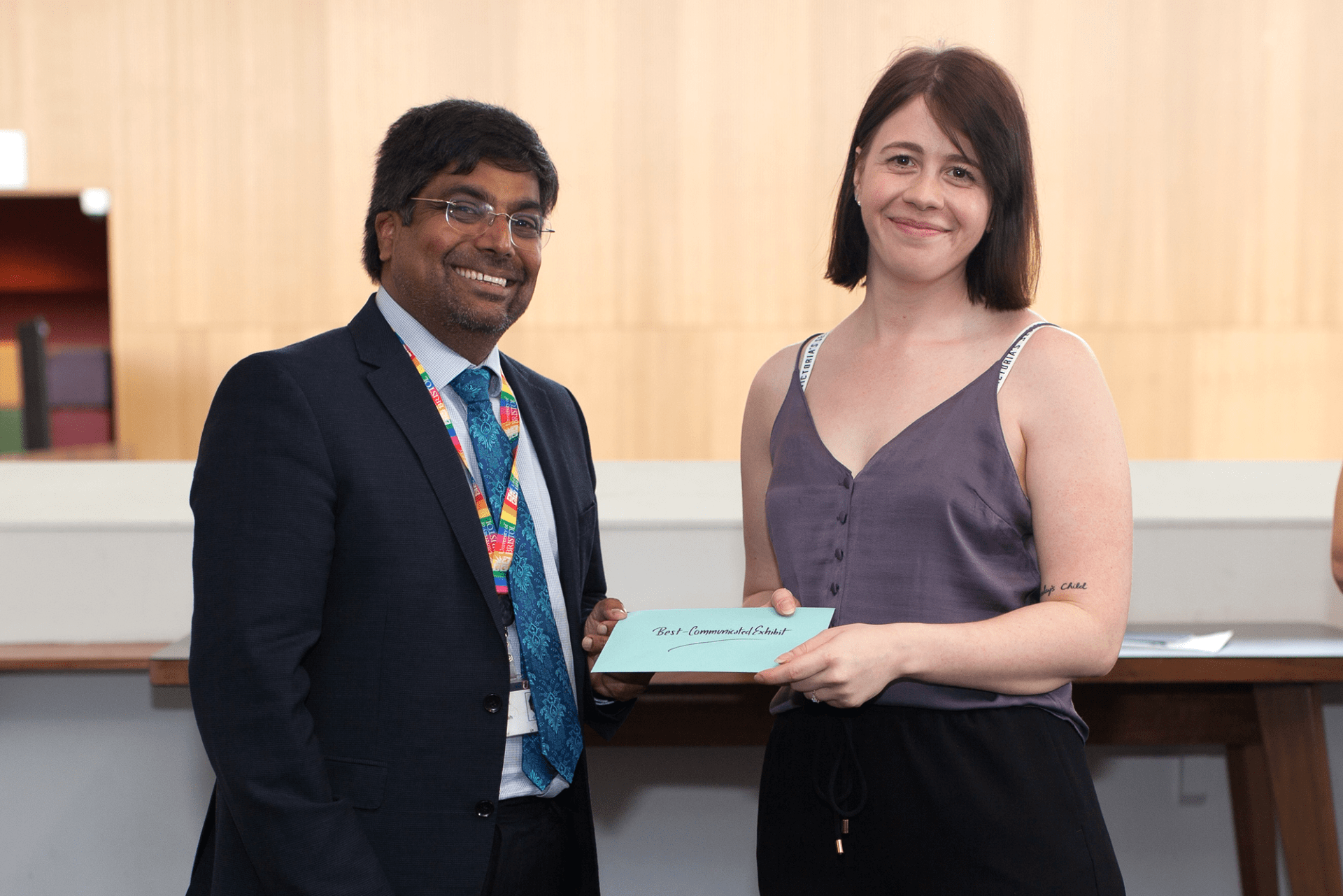 Professor Nishan Canagarajah presenting Laura Fox with the 'Best-Communicated Exhibit' prize
