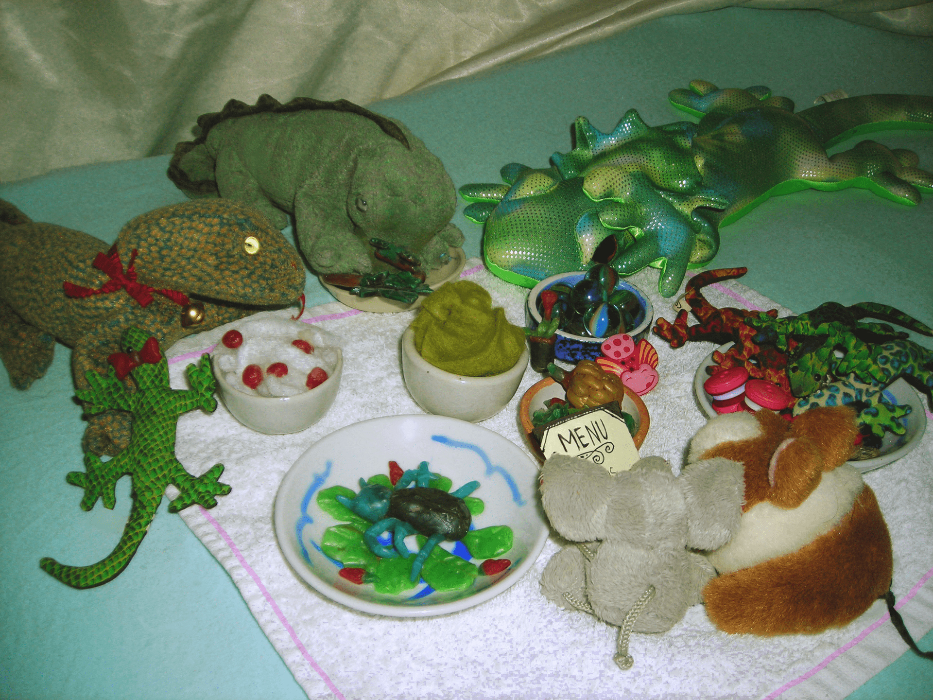 A selection of toy lizards enjoying a picnic.